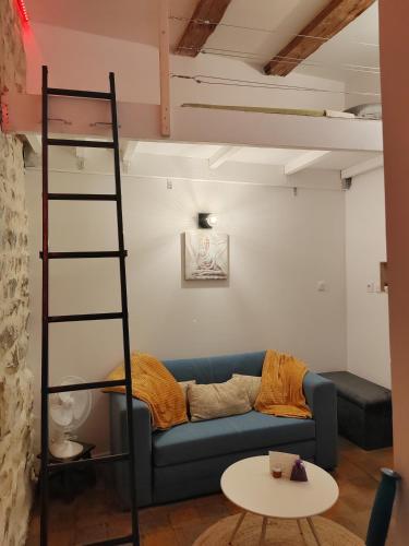 a living room with a blue couch and a ladder at Studette avec le charme de l'ancien in Avignon
