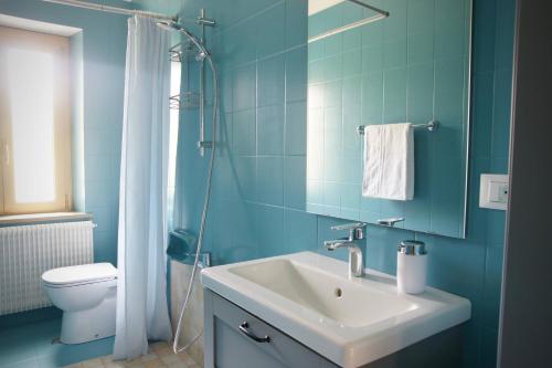 a blue bathroom with a sink and a toilet at B&B The Secret Garden in Buia