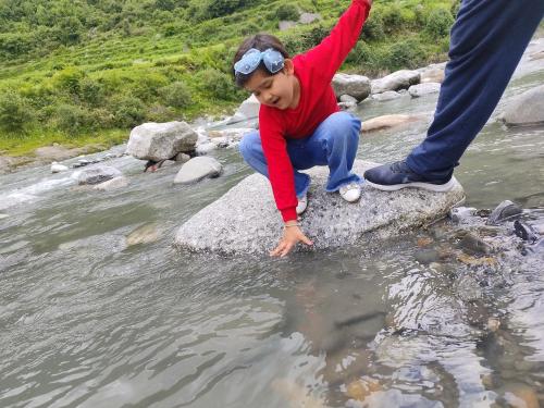 a young child is playing in the water at Pranjal home stay in Polang