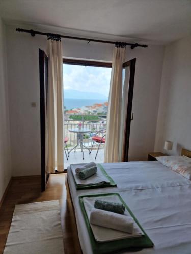 um quarto com uma cama e vista para o oceano em Apartments Palma em Gradac