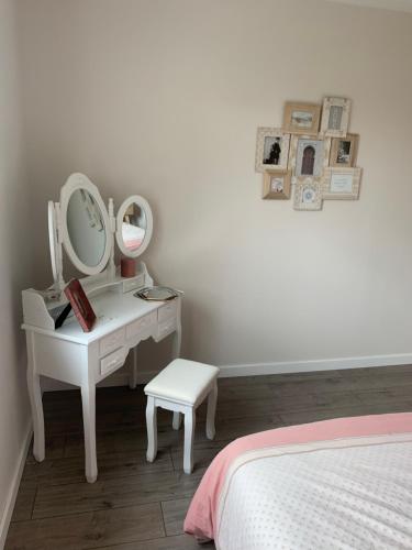 - une chambre avec une coiffeuse avec un miroir et un lit dans l'établissement Chambre moderne 24h du Mans - 10 min du circuit SDB attenante, à Laigné-en-Belin