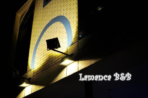 a sign on the side of a building with a light at Lamanca in Hualien City
