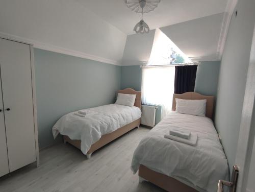 Un dormitorio con dos camas y una ventana. en Penthouse, en Trabzon