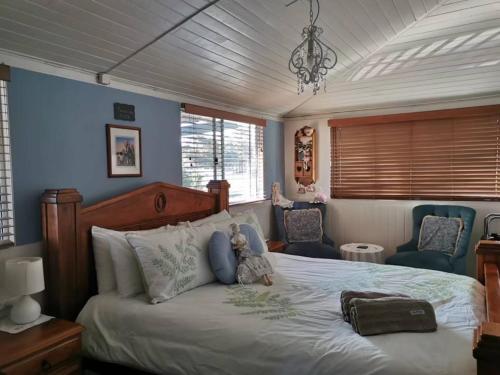 a bedroom with a large bed and two chairs at Cherry Blossom Cottage-with country charm and spa in Stanthorpe