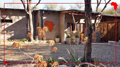 a house with trees and plants in front of it at Dream of Africa Bush Lodge in Marloth Park