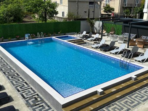 a large swimming pool with chairs around it at LIONS APARTMENT in Ureki