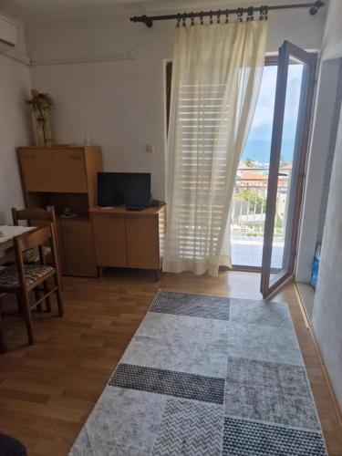 uma sala de estar com uma grande janela e uma mesa em Apartments Palma em Gradac