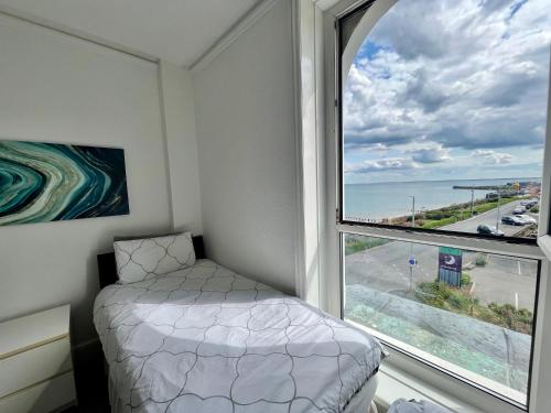 a bedroom with a bed and a large window at 7 Beach View Beaconsfield House in Bridlington