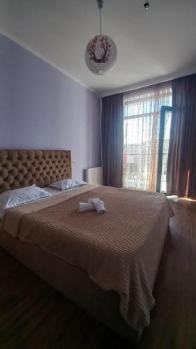 a bedroom with a large bed with two towels on it at Natia rooms in Tbilisi City