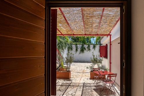 an open door to a patio with a table and chairs at Al Piglio Maison de Charme Wine & Wellness Resort in Piglio