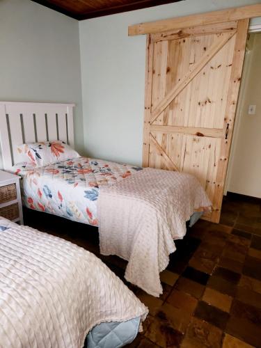 a bedroom with two beds and a barn door at 5@Stock Accommodation in Bloemfontein
