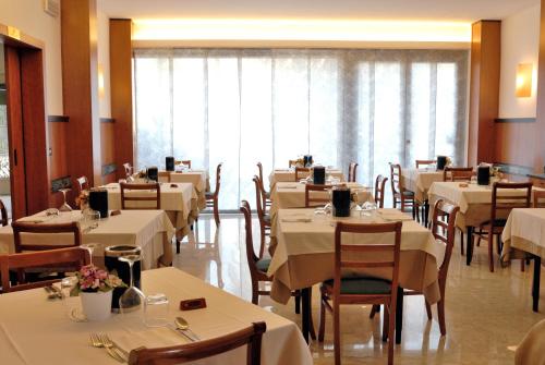 ジュリアノーヴァにあるHotel Soleのダイニングルーム(テーブル、椅子、白いテーブルクロス付)