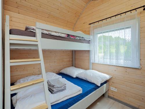 a bedroom with a bunk bed in a wooden cabin at Domki Malibu in Rusinowo