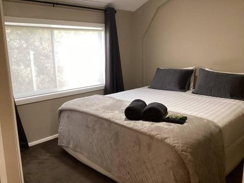 a bedroom with a large bed with two pillows on it at Strath Creek Station farm-stay in Strath Creek
