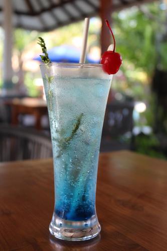 a drink with a cherry on top of a table at Puri Tempo Doeloe Boutique Hotel in Sanur