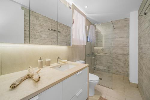 La salle de bains est pourvue d'un lavabo, de toilettes et d'une douche. dans l'établissement Junior suite by the beach Stalida, à Stalida