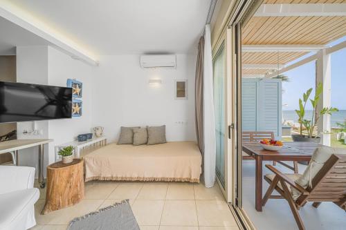 a bedroom with a bed and a balcony with the ocean at Junior suite by the beach Stalida in Stalida