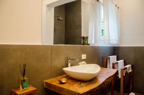 a bathroom with a white bowl sink on a wooden counter at CDM Villas Kiwengwa in Kiwengwa