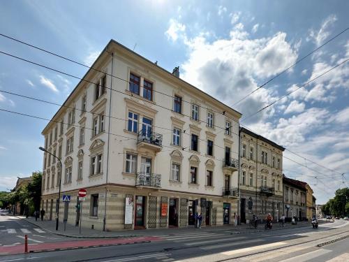 un gran edificio blanco en una calle de la ciudad en Supreme Apartment en Cracovia