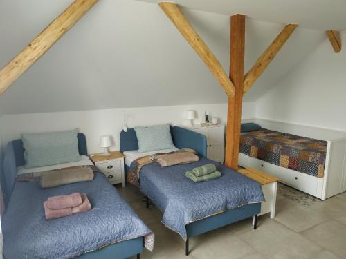 een slaapkamer met 2 bedden met blauwe lakens en kussens bij BBFamily in Balatonboglár