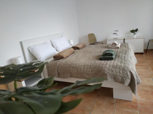 a bedroom with a bed with a blanket and pillows at BBFamily in Balatonboglár