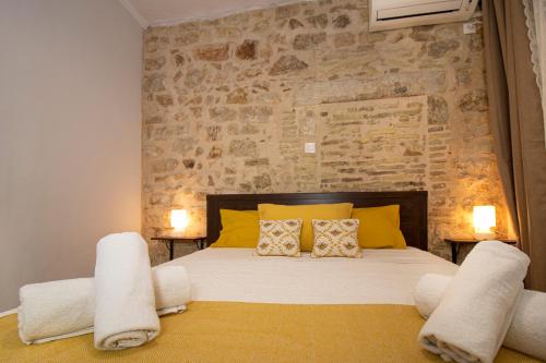 Un dormitorio con una cama grande con almohadas amarillas. en The Monastery Apartment, en Corfú