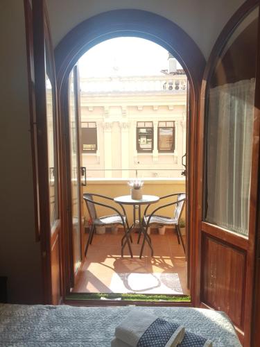 a room with an open door with a table and chairs at El BALCÓN de PILAR in Zaragoza