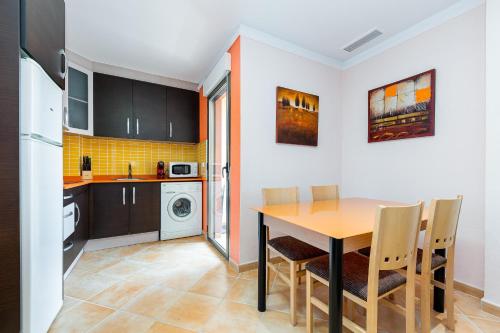 Los PalaciosにあるMediterranean Apart Los Palaciosのテーブルと椅子のあるキッチンとダイニングルーム