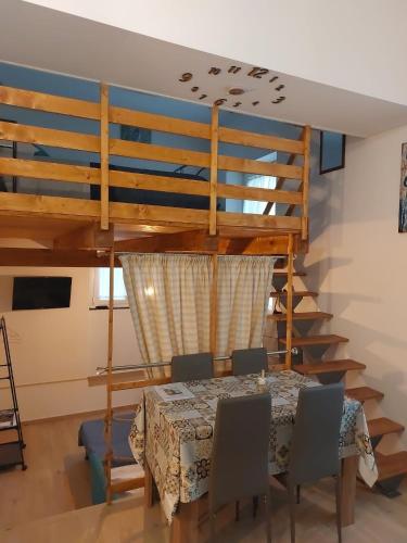 a dining room with a table and a loft at Home & Bed Spartano in Sapri