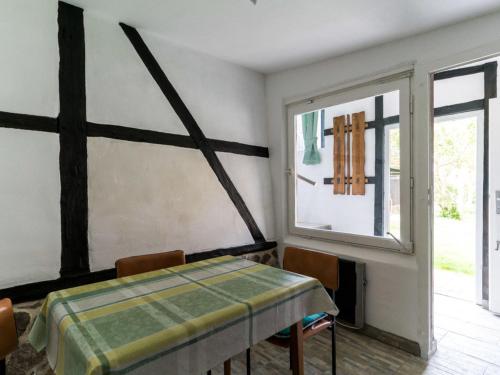 een kamer met een tafel en een kruis aan de muur bij Lake View Apartment in Klein Pravtshagen with Garden in Klein Pravtshagen