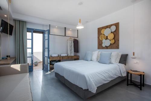 a bedroom with a large white bed and a bathroom at THALASSA in Livadia