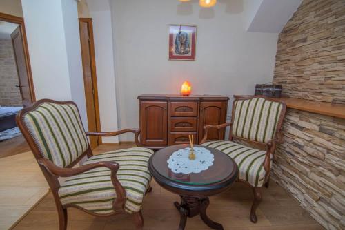 a living room with two chairs and a table with a candle at Nereo in Mali Lošinj