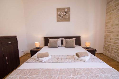 a bedroom with a large white bed with two lamps at Nereo in Mali Lošinj