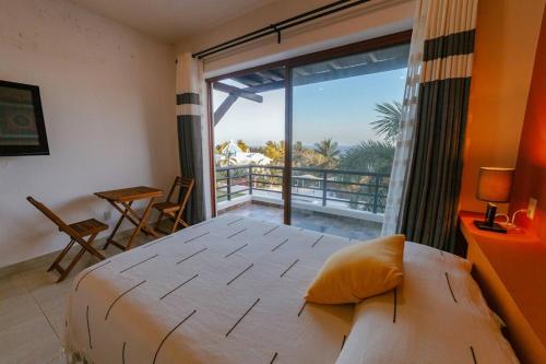 a bedroom with a large bed and a large window at Super casa, la mejor vista de Huatulco in Tangolunda