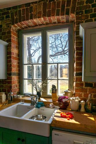 a kitchen with a sink and two windows at Villa Kingfisher in Åminnefors