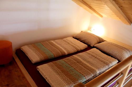 a bed in a room with two pillows on it at Melanies Guesthouse 2 Zimmerwohnung in Caldaro