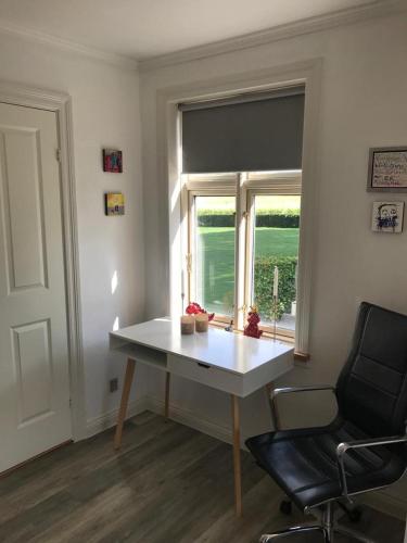 a desk in a room with a chair and a window at Den Hvide Farm in Skanderborg
