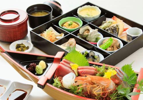a tray filled with different types of food on a table at Katsuura Hilltop Hotel & Residence in Katsuura