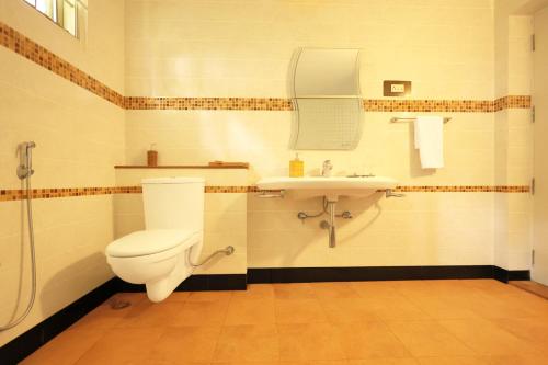 a bathroom with a toilet and a sink at Yercaud Bungalow Stay in Yercaud