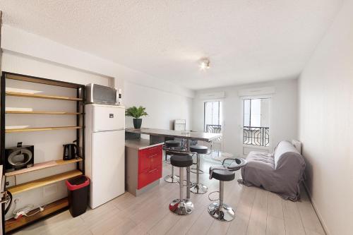 Il comprend une cuisine équipée d'un réfrigérateur, d'une table et de chaises. dans l'établissement Aka Appart'Hotel 