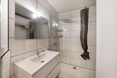 Baño blanco con lavabo y espejo en Aka Appart'Hotel " Le Petit Coin de Lavaur", en Lavaur