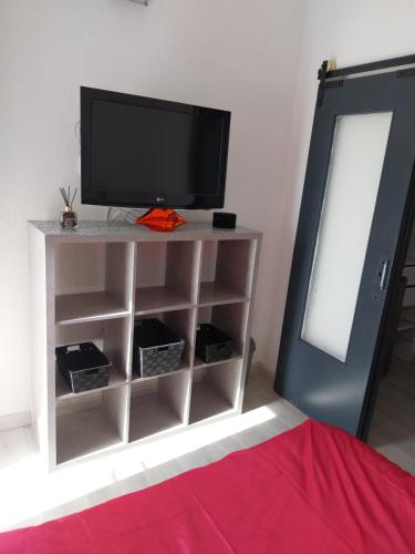 - une télévision sur un support dans l'établissement CHARMANT STUDIO VILLAGE NATURISTE CAP AGDE, au Cap d'Agde