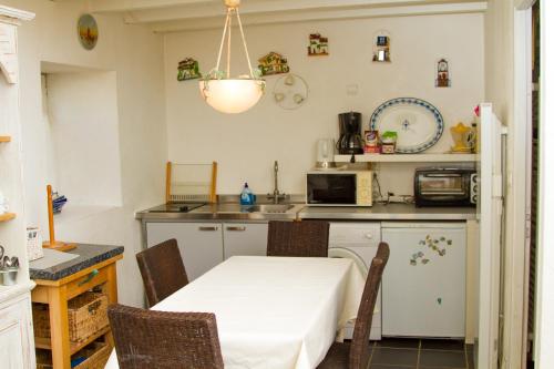 Gite de la Laiterie في Bouaye: مطبخ مع طاولة وكراسي في غرفة