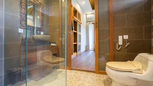 a bathroom with a toilet and a glass shower at KajaNe Mua at Ubud Bali in Ubud