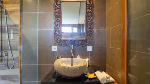 a bathroom with a sink and a mirror at KajaNe Mua at Ubud Bali in Ubud