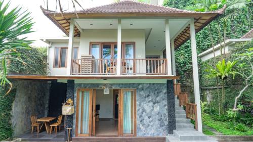 a villa with a balcony and a house at KajaNe Mua at Ubud Bali in Ubud