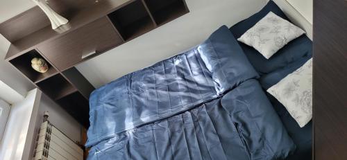Sofá azul en un dormitorio con 2 almohadas en Szpitalna 9c en Suwałki