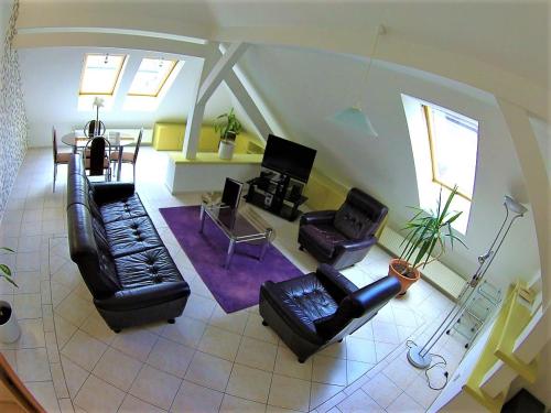 a living room with black leather furniture and a table at Hotel Vacek Pod Věží in Hradec Králové