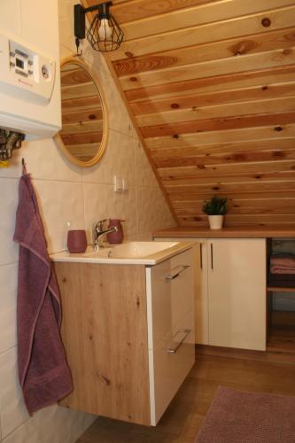 布倫納的住宿－Apartament Wrzosowisko，一个带水槽和木制天花板的厨房