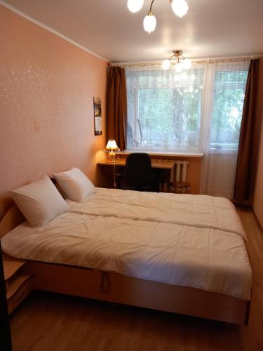 a bedroom with a bed and a desk and a table at Dzintari in Jūrmala